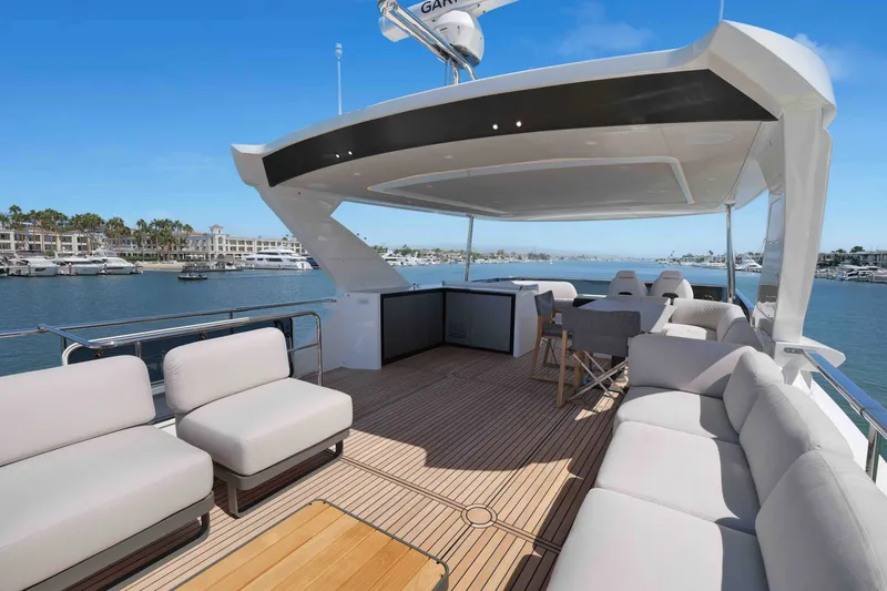 Slide: The Image of Luxurious 2027 Absolute Navetta 62 yacht deck with elegant seating and scenic marina view. - 12