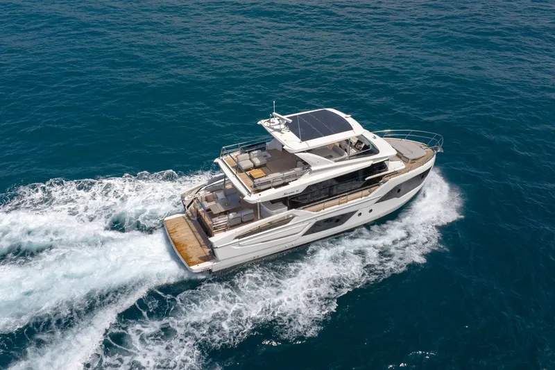 Slide: The Image of Luxurious 2027 Absolute Navetta 62 yacht cruising on open sea, showcasing sleek design. - 6