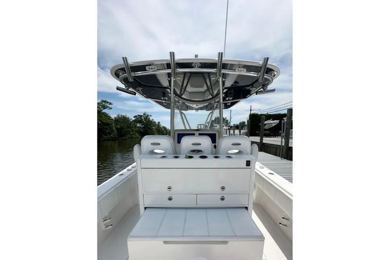 Slide: The Image of 2019 Contender 35 ST boat interior with seating and console, docked by a calm waterway. - 13