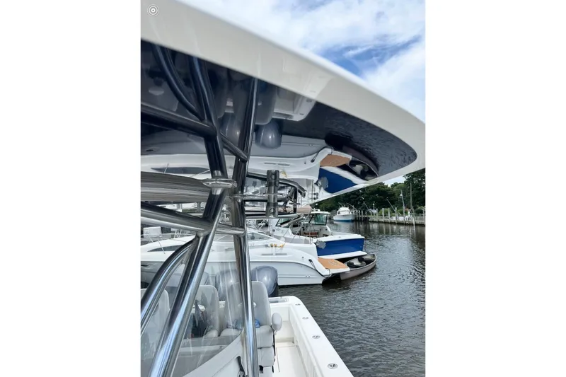 Slide: The Image of 2019 Contender 35 ST boat docked, showcasing sleek design and stainless steel framework. - 16