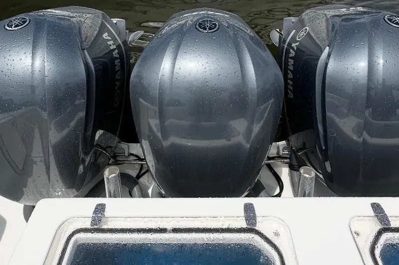 Slide: The Image of Triple Yamaha outboard engines on a 2019 Contender 35 ST boat, wet with water droplets. - 17