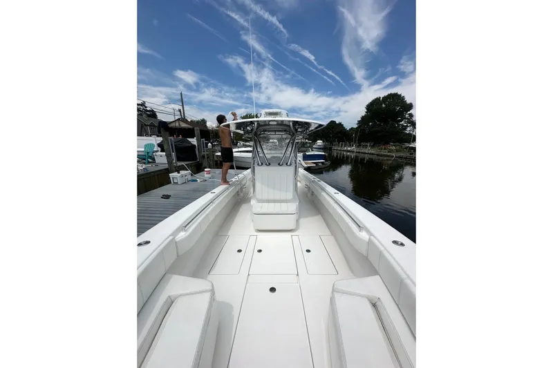 Slide: The Image of 2019 Contender 35 ST boat docked, featuring spacious deck and clear sky. - 8