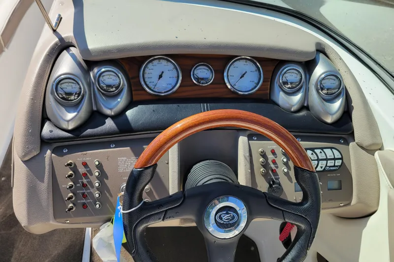 Slide: The Image of Dashboard of a 2006 Cobalt 250 boat with gauges and wooden steering wheel. - 10