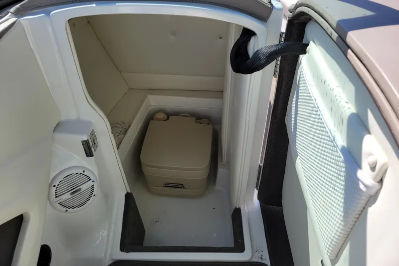 Slide: The Image of 2006 Cobalt 250 boat interior with portable toilet and storage compartment. - 17