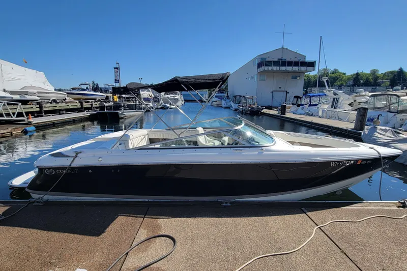 Slide: The Image of 2006 Cobalt 250 boat docked at marina under clear blue sky. - 2