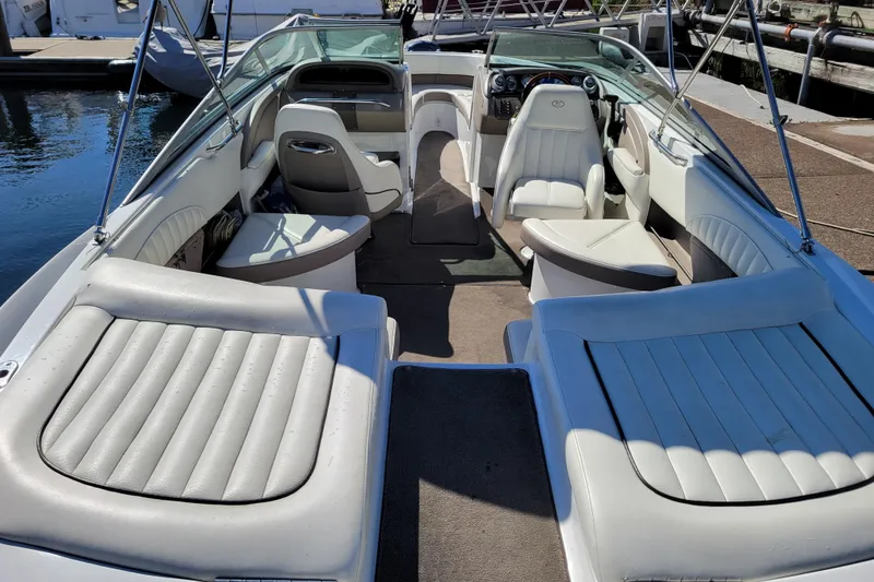Slide: The Image of 2006 Cobalt 250 boat interior with white seating, docked by the water. - 4