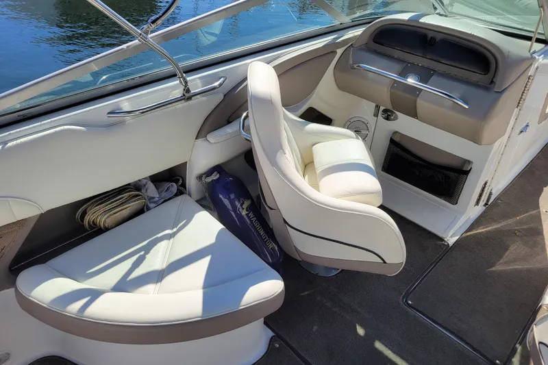 Slide: The Image of Interior of a 2006 Cobalt 250 boat with white seating and dashboard. - 6
