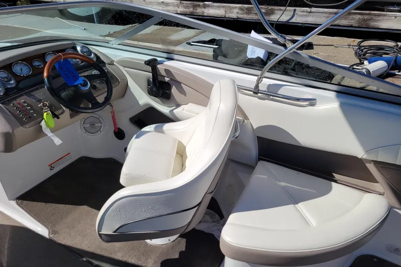 Slide: The Image of Interior of a 2006 Cobalt 250 boat with white seating and control panel. - 7