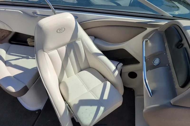 Slide: The Image of Interior of a 2006 Cobalt 250 boat featuring white leather seating and dashboard details. - 8