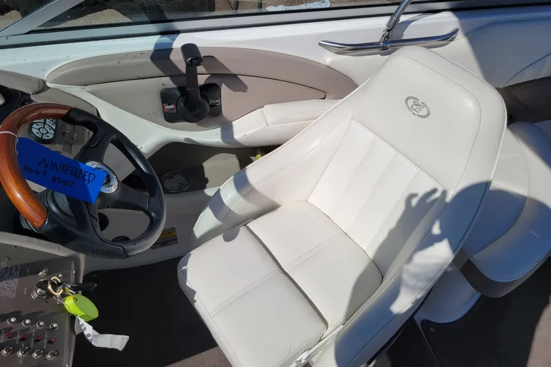Slide: The Image of Interior of a 2006 Cobalt 250 boat with white seating and steering wheel. - 9