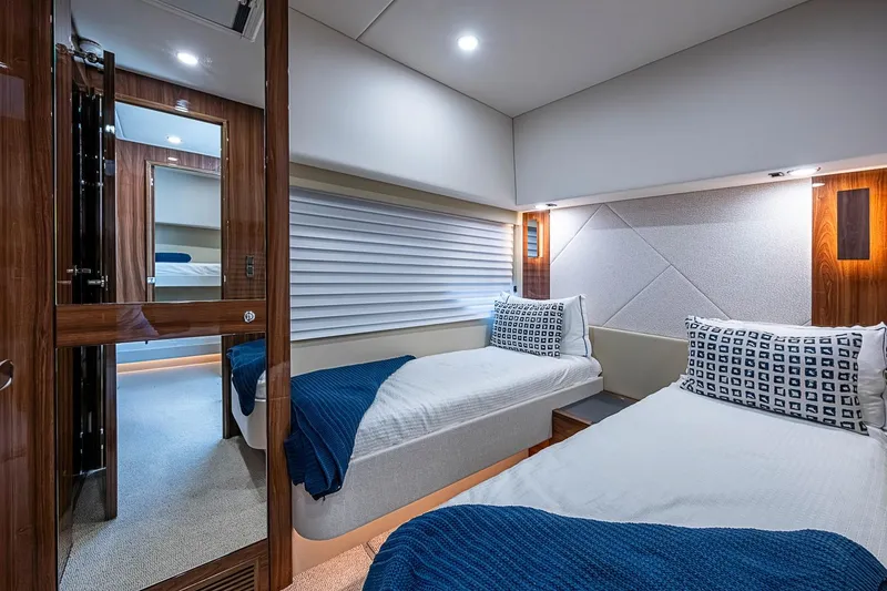 Slide: The Image of Luxurious twin cabin interior of 2025 Maritimo M75 yacht, featuring modern design and cozy bedding. - 78