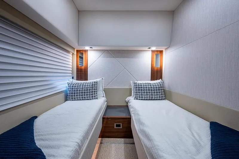 Slide: The Image of Luxurious twin cabin interior of 2025 Maritimo M75 yacht, featuring modern design and cozy bedding. - 79