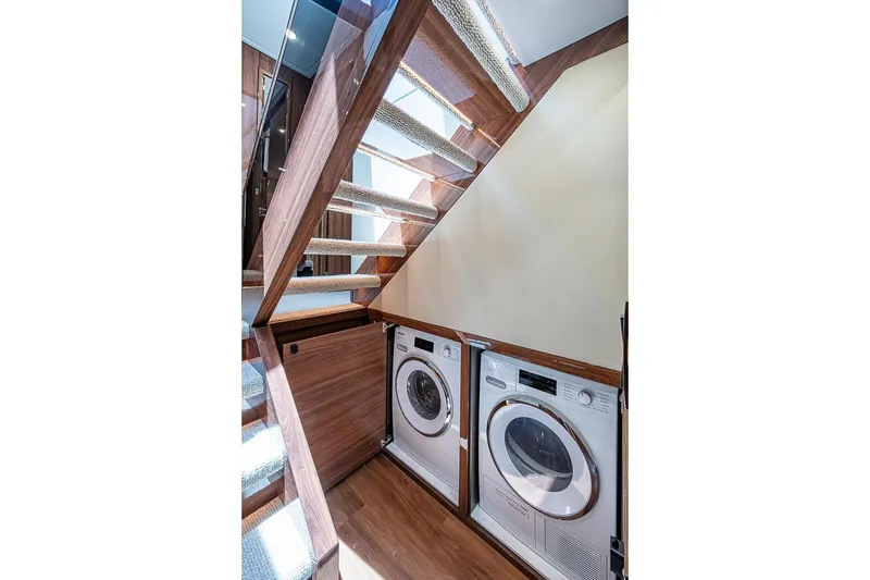 Slide: The Image of Laundry area under stairs in 2025 Maritimo M75 yacht, featuring modern appliances. - 93