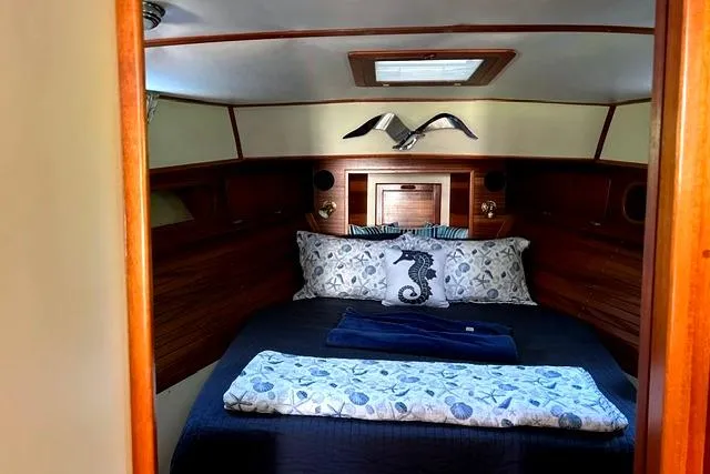 Slide: The Image of Cozy cabin interior of a 2000 Duffy 42 boat with nautical-themed bedding. - 26