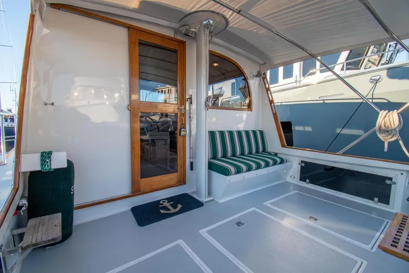 Slide: The Image of Spacious deck of 2000 Duffy 42 boat with striped seating and wooden door. - 4