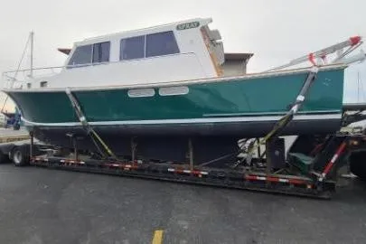 Slide: The Image of 2000 Duffy 42 boat on trailer, green hull, white cabin, docked in a marina. - 5