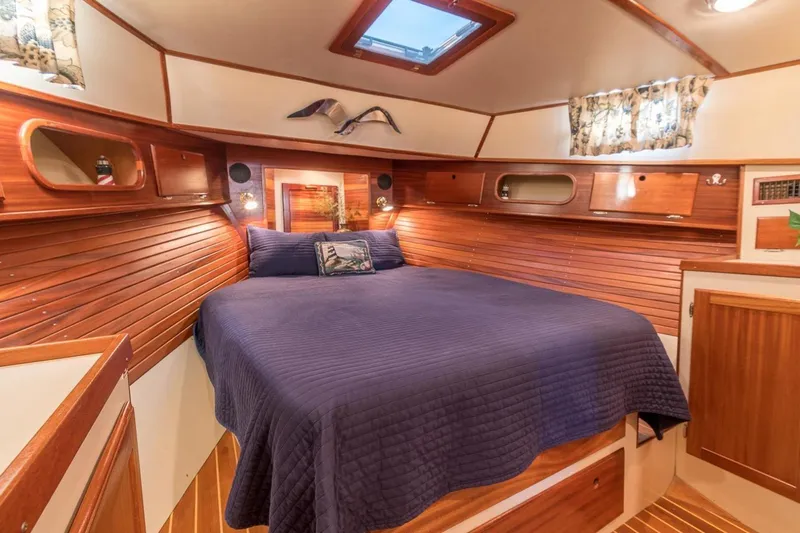 Slide: The Image of Cozy cabin interior of 2000 Duffy 42 boat with wooden accents and blue bedding. - 9