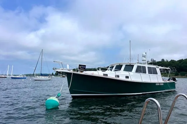 The Image of Duffy 42 boat from 2000 anchored in a scenic harbor with sailboats. - 0