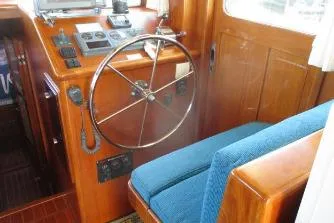 Slide: The Image of Helm of 2007 Mariner 40 Orient boat with wooden finish and blue seating. - 36