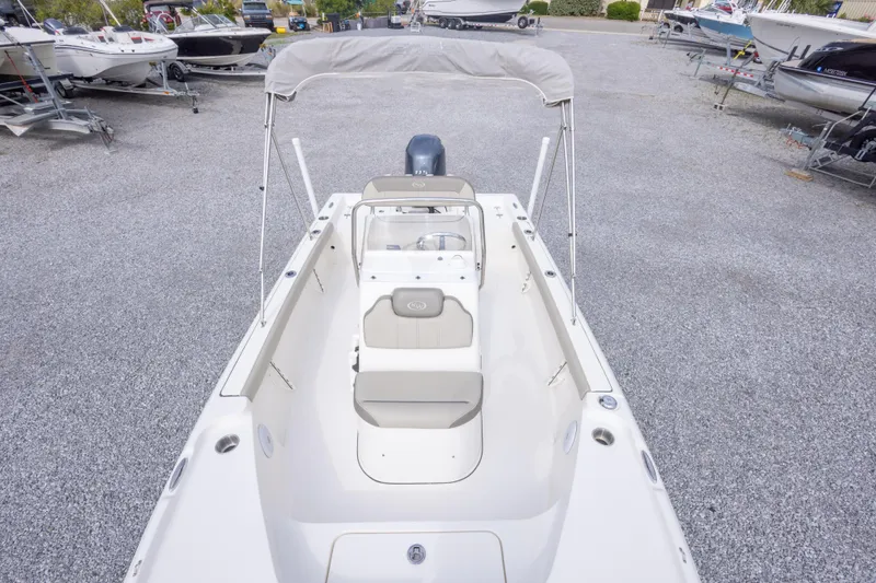 Slide: The Image of 2023 Key West 188 Bay Reef boat with seating and canopy, parked on gravel lot. - 27