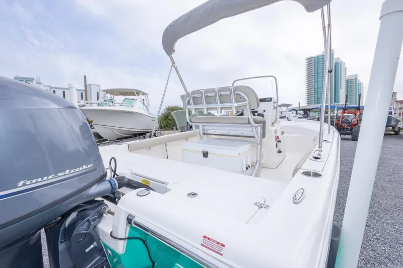 Slide: The Image of 2023 Key West 188 Bay Reef boat with four-stroke engine, docked near modern buildings. - 30