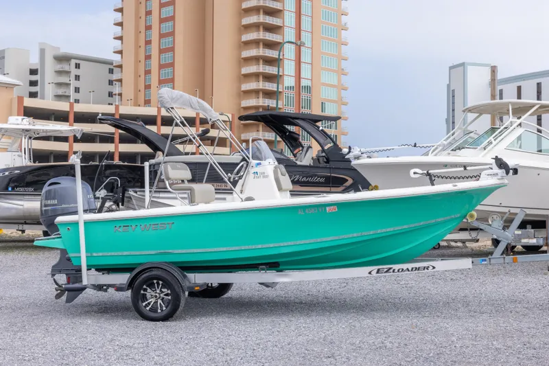 Slide: The Image of 2023 Key West 188 Bay Reef boat on trailer, parked near modern buildings. - 33