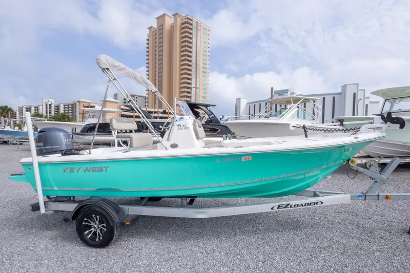 Slide: The Image of 2023 Key West 188 Bay Reef boat on trailer, cityscape background. - 4