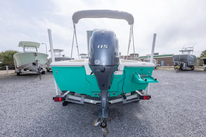 Slide: The Image of 2023 Key West 188 Bay Reef boat with outboard motor, parked on gravel. - 9