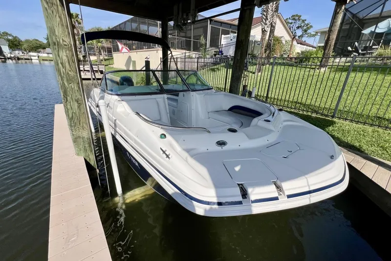 Slide: The Image of 2013 Hurricane SunDeck 187 OB boat docked in a serene waterfront setting. - 16