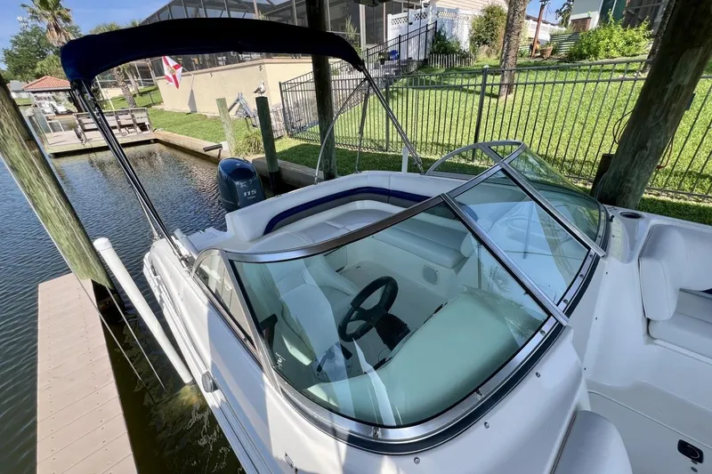 Slide: The Image of 2013 Hurricane SunDeck 187 OB boat docked, featuring a sleek design and spacious seating. - 18