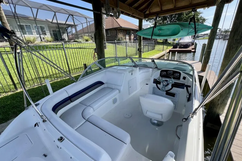 Slide: The Image of 2013 Hurricane SunDeck 187 OB boat docked, featuring spacious seating and steering console. - 19