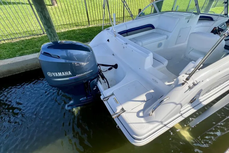 Slide: The Image of 2013 Hurricane SunDeck 187 OB boat with Yamaha outboard motor, docked in calm water. - 20