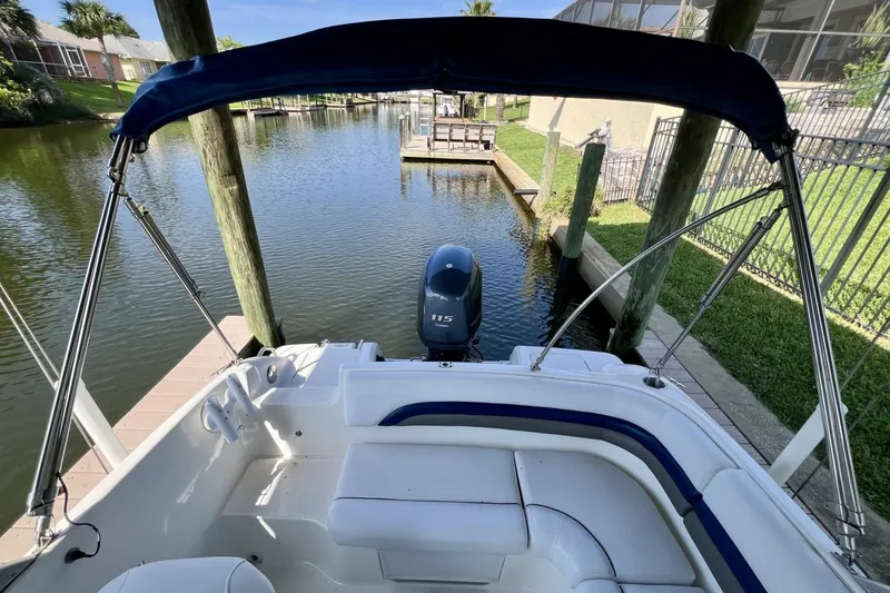 Slide: The Image of 2013 Hurricane SunDeck 187 OB boat docked in a serene canal setting. - 31
