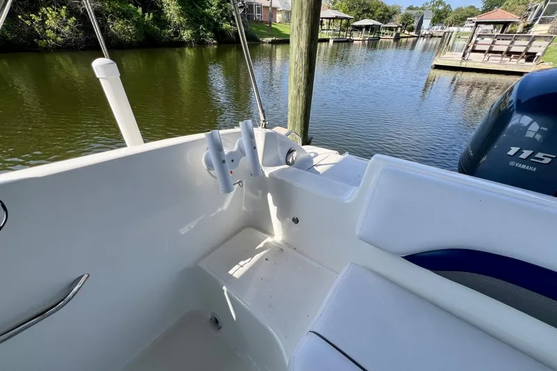 Slide: The Image of 2013 Hurricane SunDeck 187 OB boat interior with Yamaha 115 engine by a serene canal. - 32