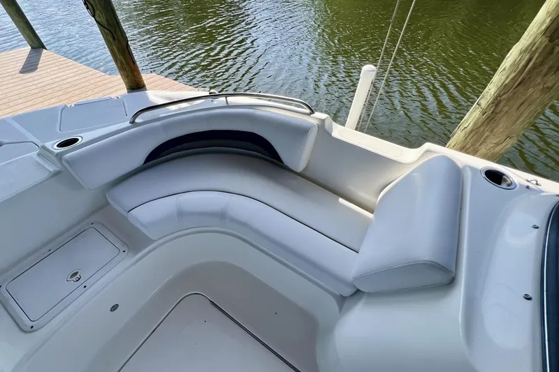Slide: The Image of 2013 Hurricane SunDeck 187 OB boat interior with white seating and cup holders by the water. - 34
