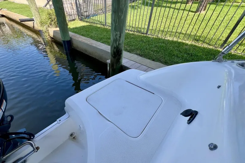 Slide: The Image of 2013 Hurricane SunDeck 187 OB boat docked near grassy area and water. - 41