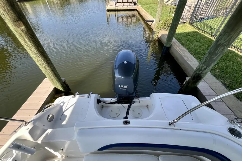 Slide: The Image of 2013 Hurricane SunDeck 187 OB boat with Yamaha 115 outboard motor docked in calm water. - 43