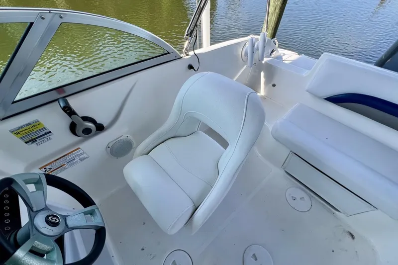 Slide: The Image of 2013 Hurricane SunDeck 187 OB boat interior with white seating and steering wheel. - 44