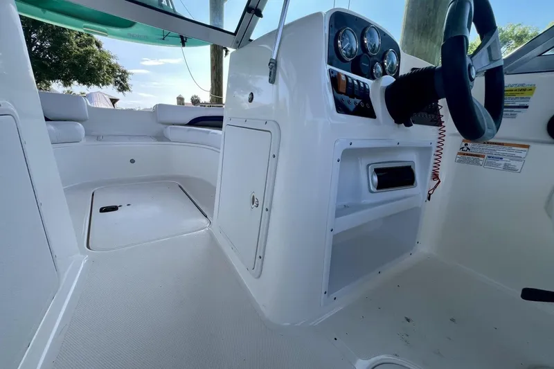 Slide: The Image of 2013 Hurricane SunDeck 187 OB boat interior with steering console and seating area. - 51