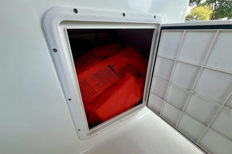 Slide: The Image of Storage compartment with orange life jackets on a 2013 Hurricane SunDeck 187 OB boat. - 52