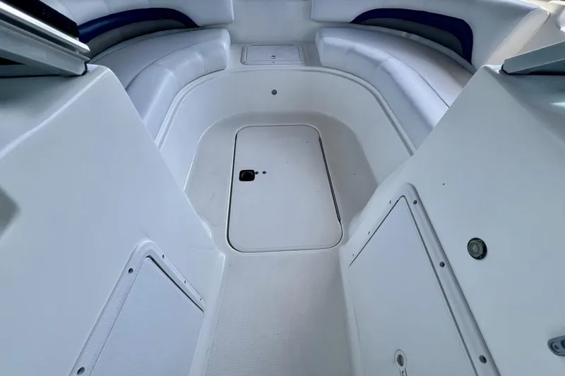 Slide: The Image of Interior view of a 2013 Hurricane SunDeck 187 OB boat, featuring white seating and storage compartments. - 55