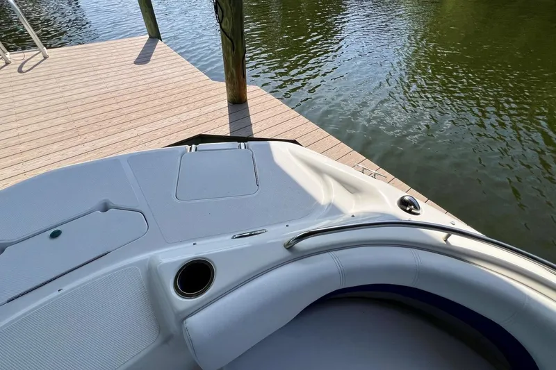 Slide: The Image of 2013 Hurricane SunDeck 187 OB boat docked by a wooden pier on calm water. - 56