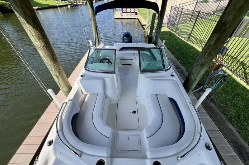 Slide: The Image of 2013 Hurricane SunDeck 187 OB boat docked, featuring spacious seating and sleek design. - 58