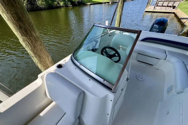 Slide: The Image of 2013 Hurricane SunDeck 187 OB boat interior with steering wheel, docked by water. - 61