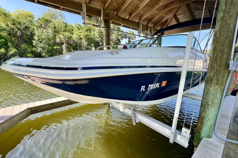 Slide: The Image of 2013 Hurricane SunDeck 187 OB boat docked under a wooden canopy. - 76