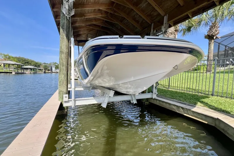 Slide: The Image of 2013 Hurricane SunDeck 187 OB boat on lift by waterfront dock. - 82