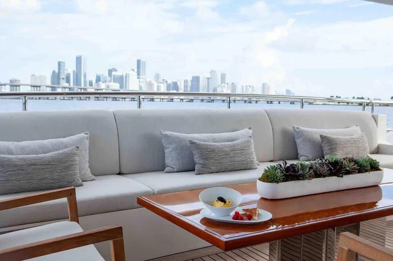 Slide: The Image of Luxurious Benetti Classic Supreme 132 yacht deck with elegant seating and city skyline view. - 10