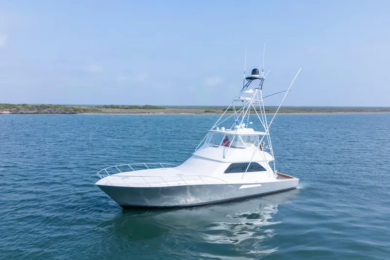 The Image of 2005 Viking Convertible yacht on calm waters near a scenic shoreline. - 0