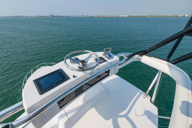 Slide: The Image of Helm of 2005 Viking Convertible yacht overlooking calm ocean waters. - 12