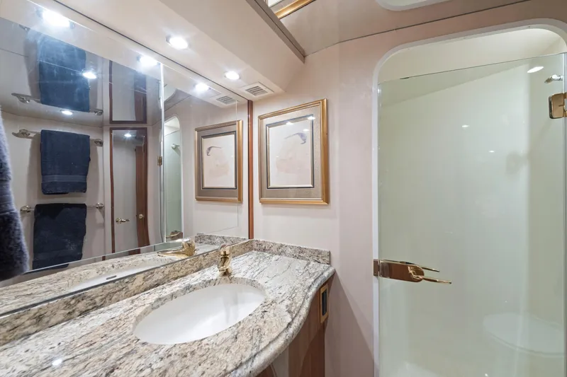 Slide: The Image of Luxurious bathroom in a 2005 Viking Convertible yacht with granite countertop and glass shower. - 32